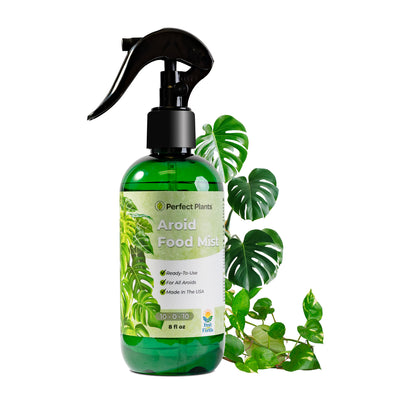 A bottle of Aroid Fertilizer Mist by Perfect Plants with a spray nozzle, labeled for 10-0-10 NPK, against a background with green leaves.