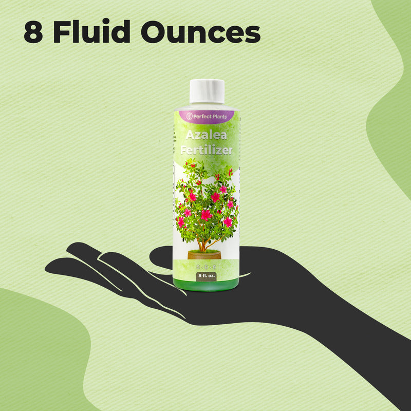 Bottle of azalea fertilizer held in a hand with &