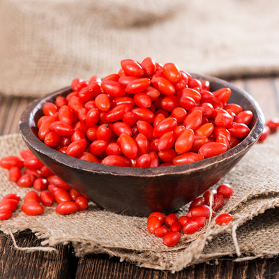 Ripe red goji berries in brown bowl for baked goods and cooking